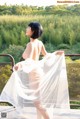 A woman in a white dress standing on a balcony.