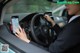 A woman in a car using a cell phone while driving.