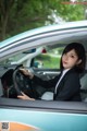 A woman in a business suit sitting in a car.