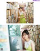 A woman in a green dress standing in front of a book shelf.