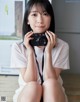 A woman sitting on the floor holding a camera.