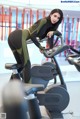 A woman on a stationary bike in a gym.