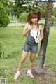 A woman standing next to a palm tree in a park.