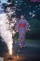 A woman in a kimono holding a sparkler in her hand.