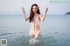 A woman in a pink bikini standing in the water.