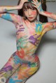 A woman with a body painted in bright colors.