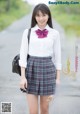 A young woman in a school uniform is posing for a picture.