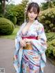 A woman in a blue kimono posing for the camera.