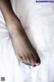 A close up of a person's foot on a bed.