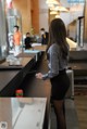 A woman standing at a counter in a restaurant.