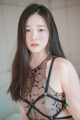 A woman with long black hair wearing a black lingerie.