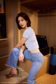 A woman sitting on top of a shelf in a room.