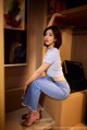 A woman sitting on top of a wooden shelf.