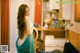 A woman in a blue dress standing in a kitchen.