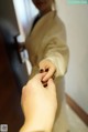 A woman in a beige jacket is putting a ring on another woman's finger.