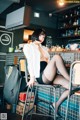 A woman sitting on a bar stool in a restaurant.