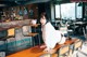 A woman sitting on top of a wooden table in a restaurant.