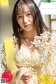 A woman holding a bunch of flowers in her hands.