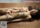 A naked woman laying on a wooden table covered in sushi.