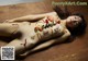 A naked woman laying on a wooden table covered in sushi.