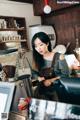 A woman standing behind a counter in a coffee shop.