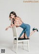 A woman sitting on top of a white chair.