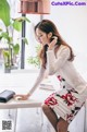 A woman sitting at a table talking on a cell phone.