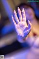 A woman's hand is covered in water droplets. 