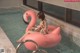 A woman sitting on an inflatable flamingo in a swimming pool.