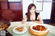 A woman sitting at a table with a plate of food.