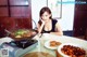 A woman sitting at a table with a bowl of food.