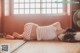 A woman laying on the floor in front of a fan.